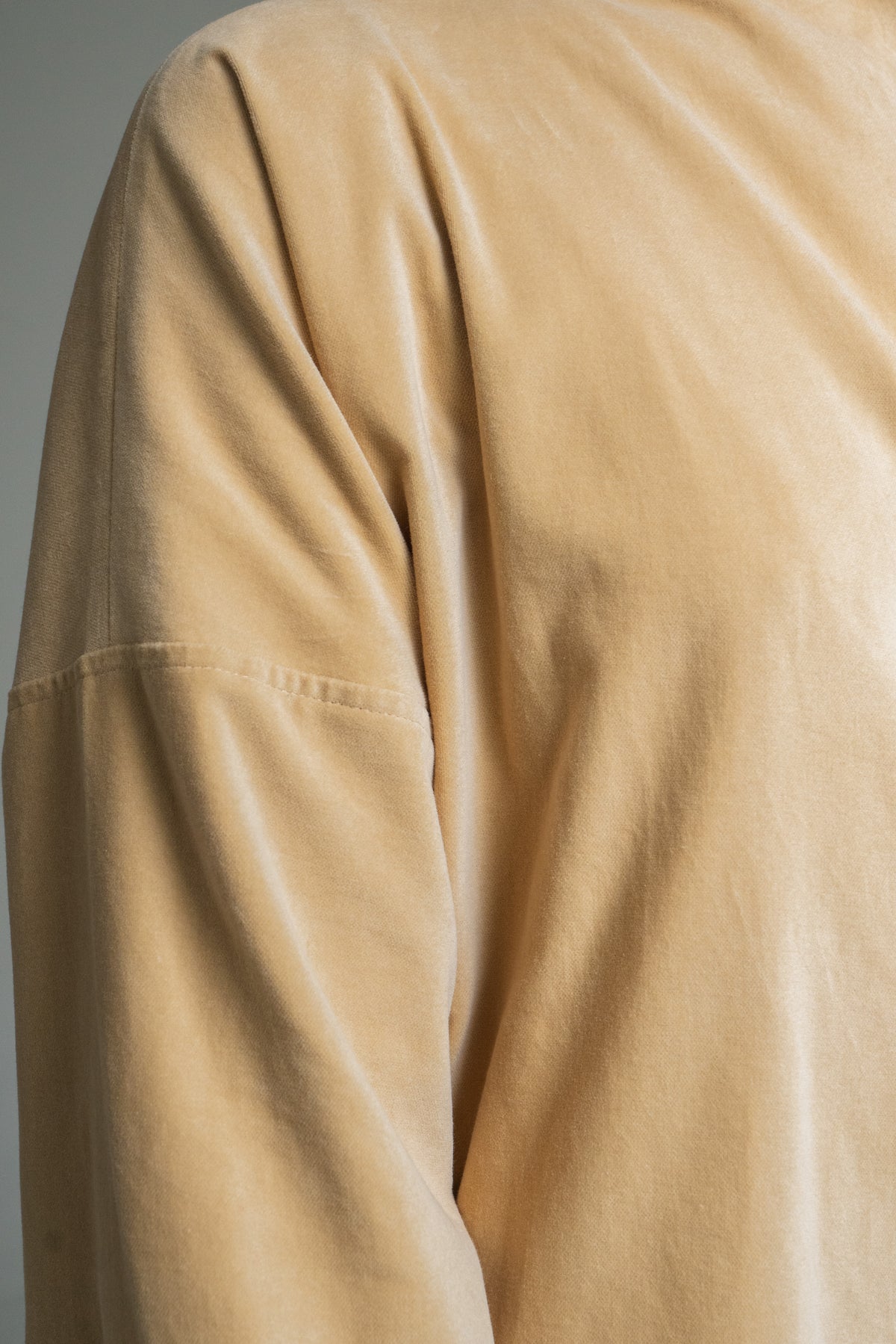Close-up of a Mustard yellow duster coat with a plain background