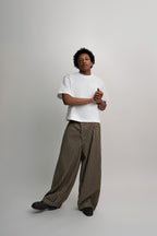 Person wearing a white t-shirt and checkered pants on a plain background